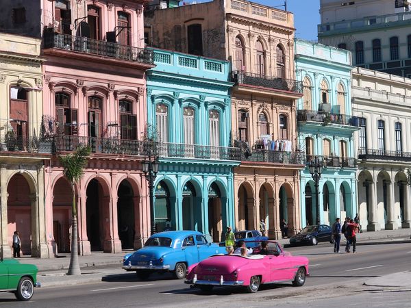 Felgekleurde huizen en oldtimers in een straat in Havanna, Cuba.